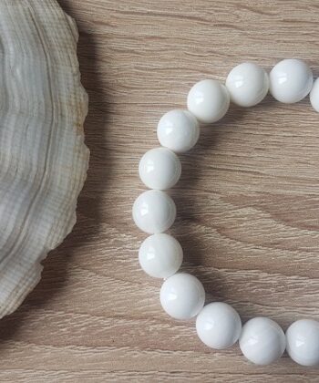 Bracelet élastique composé de White Shell appelée également Perle du Bénitier. C’est une véritable Perle Porte-Bonheur. Les perles de bénitier sont produites par les tridacnes géants. C’est un mollusque géant produisant de magnifiques perles de nacre blanche, semblable à de la porcelaine et d’une grande pureté.