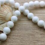 Collier en fil de bijoutier composé de Perle de White Shell appelé également « perle de bénitier ». Collier en pierre naturelle, fil de bijoutier renforcé, fabrication artisanale française. C’est une véritable Perle Porte-Bonheur. Les perles de bénitier sont produites par les tridacnes géants. C’est un mollusque géant produisant de magnifiques perles de nacre blanche, semblable à de la porcelaine et d’une grande pureté.