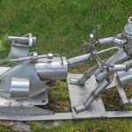 Sculpture Métallique Valentino scooter des neiges : Embellissez votre jardin ou votre intérieur avec le scooter des neiges de Franck Valentino, une œuvre artistique qui évoque une interprétation libre d'un scooter des neiges ou lugeur  des neiges industrielles.. Vision extraordinaire futuriste affrontant la nature plus forte que l'homme et "le Métal Perk". Il s'agit de l'œuvre n* 137 de Franck Valentino, un sculpteur connu à Annonay, pour laisser libre cours à son imagination et réaliser des œuvres inspirées ou toutes droites sorties de son imagination. Cet artiste "Touche à tout" a réalisé de nombreuses œuvres. Cette fois ci il signe une œuvre surprenante contemporaine. Cette sculpture affronte l'extérieur et le climat depuis sa réalisation, tentant de gravir parfois un arbre, parfois parcourant certaines zones de son jardin en attirant l'attention des visiteurs qui ont la chance de pouvoir admirer ses Œuvres rocambolesques et Originales exposées chez lui ou dans son jardin.