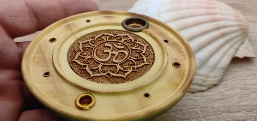 Décoratif et indispensable pour les rituels de purification et les cérémonies avec encens. Brûleur d'encens, orné d'une décoration avec un lotus Om gravé. Convient pour brûler les cônes d'encens et les fins bâtonnets d'encens, comme l'encens indien et japonais. Type de bois : Papri (orme indien) Taille : 10 x 10 x 2.5 cm Couleur : naturel du bois Matériel : Type de bois: Papri (orme indien) Poids total gr : 70-80 gr